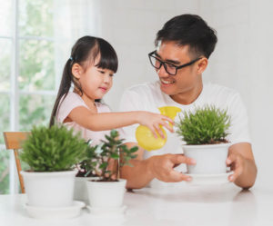 father and daughter watering pants