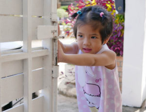 child pushing a gate