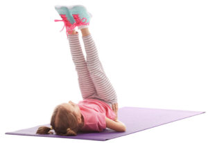 girl lying on back pointing toes in the air