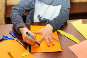 child tracing hand on paper