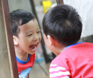 Smiling boy looking in a mirror