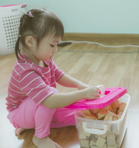 Girl picking up toys