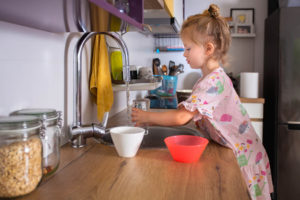 girl fills a glass with water