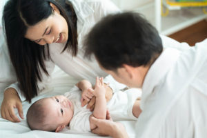 father and mother are playing with newborn 